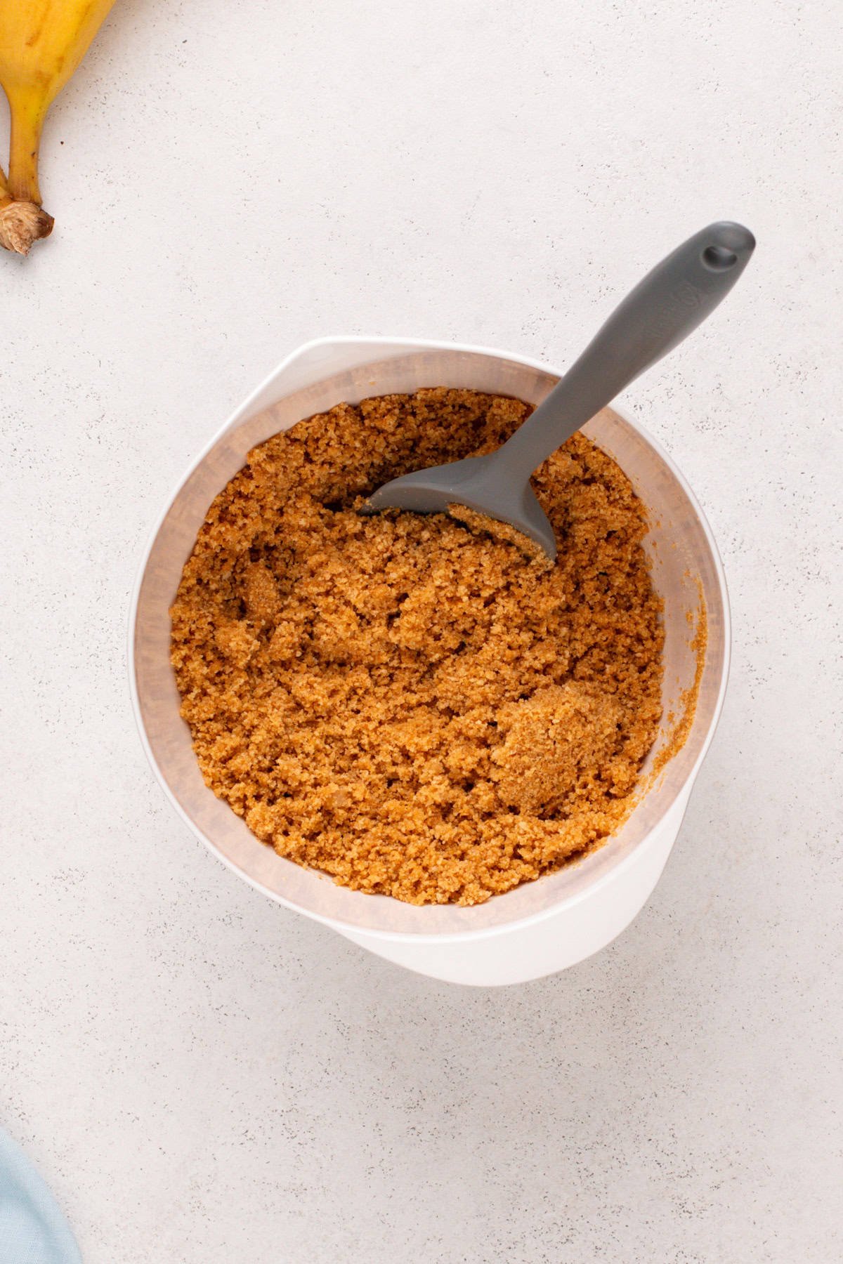 Graham cracker crust mixture in a white bowl.