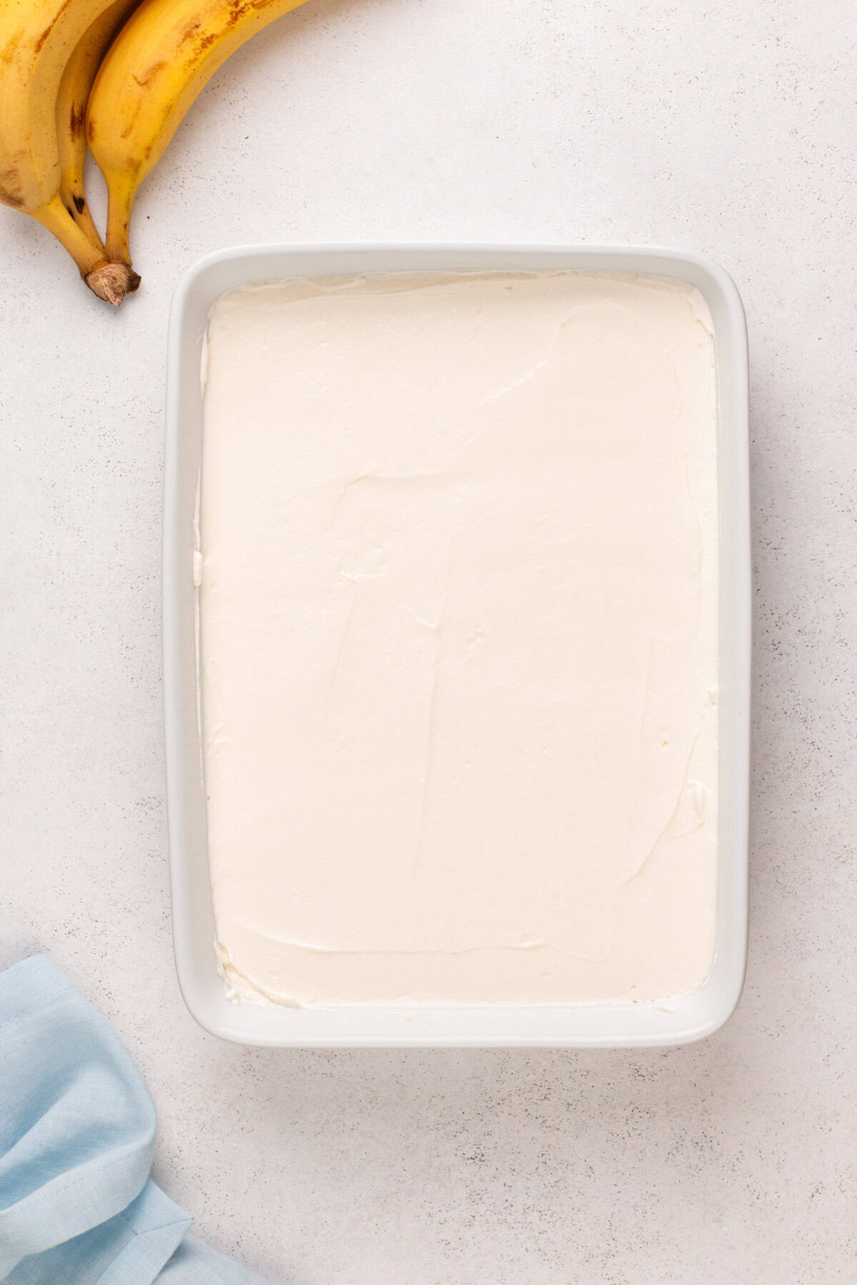 Cream cheese filling spread in a baking dish.