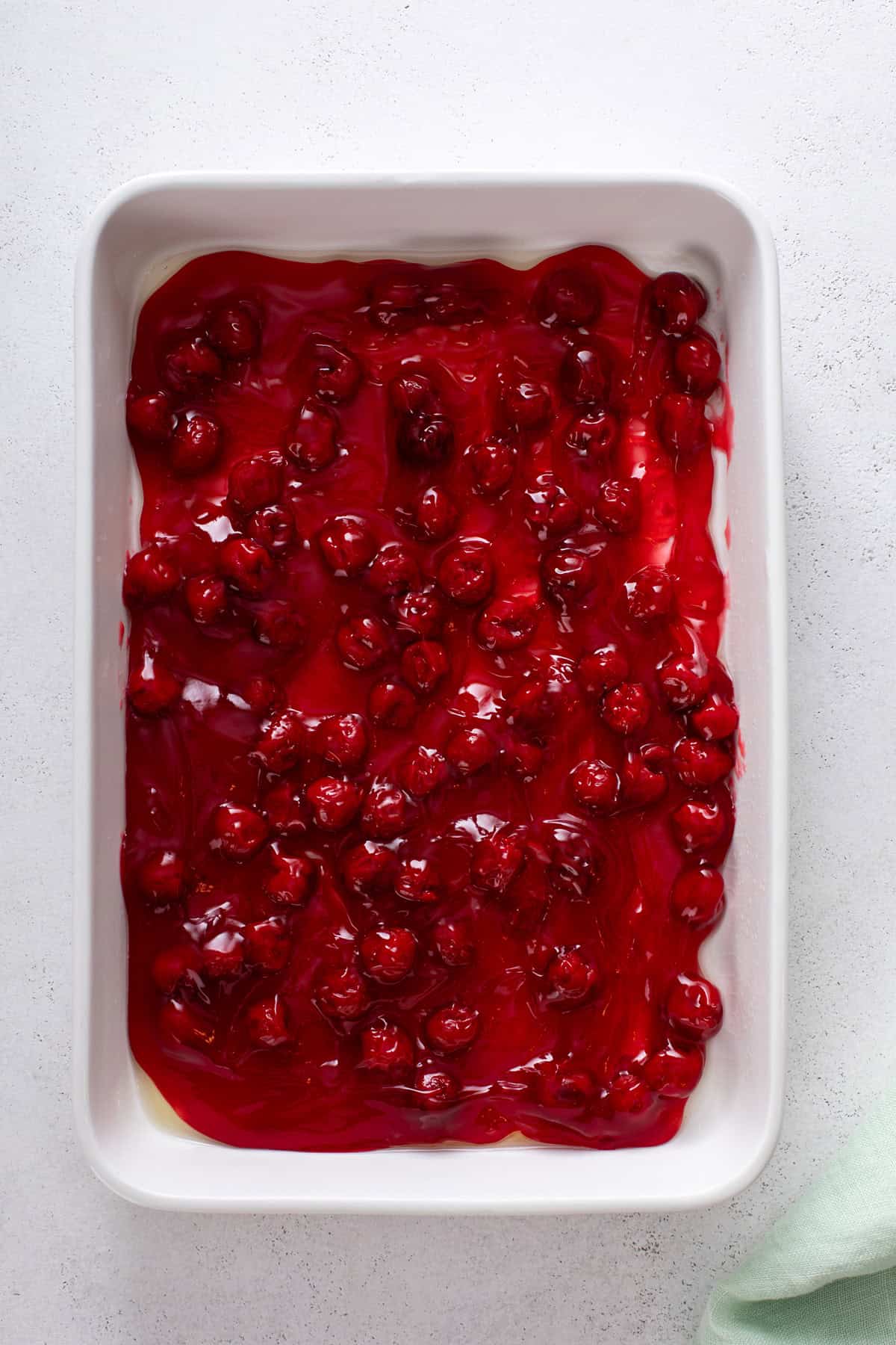 Cherry pie filling spread into the bottom of a baking dish.