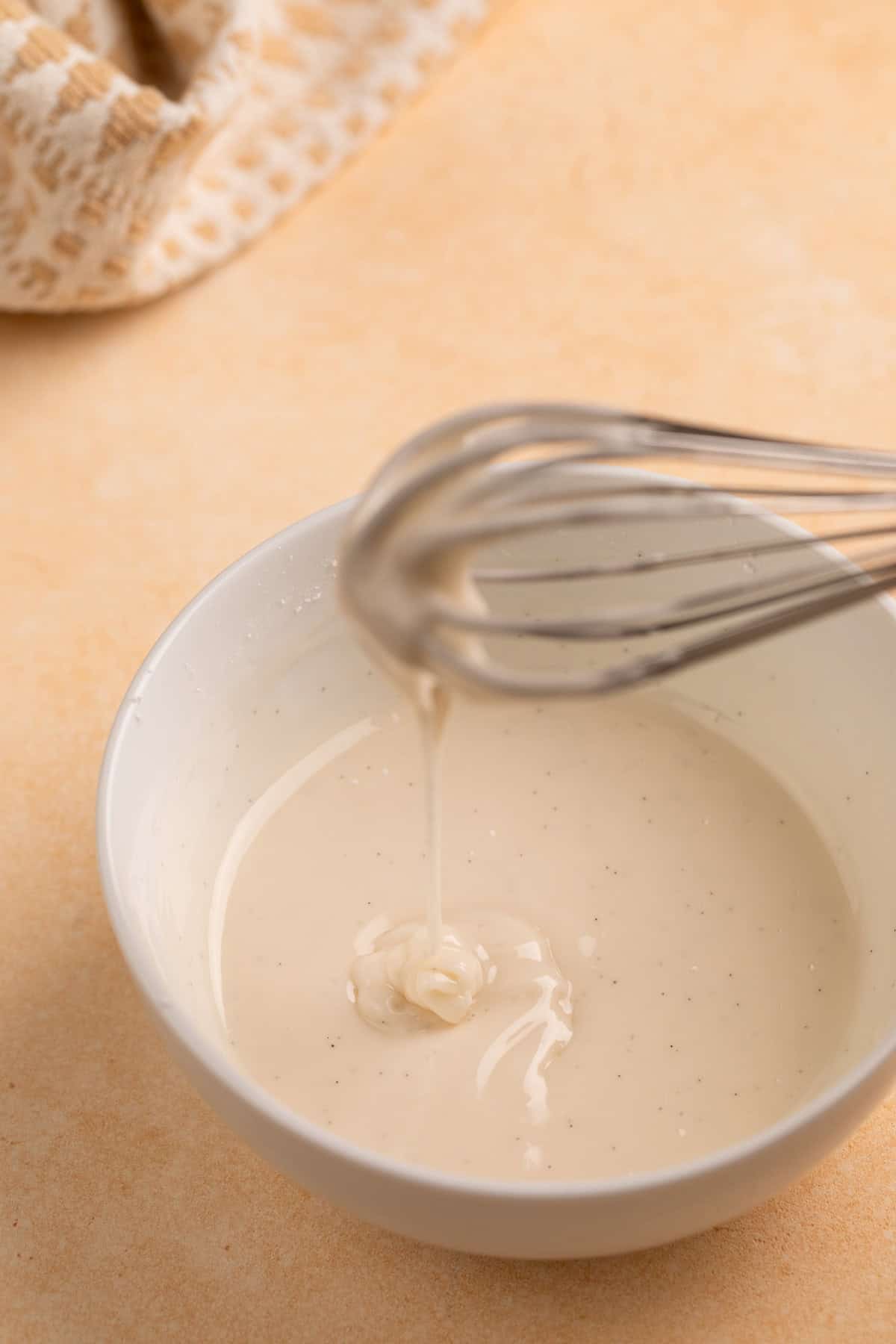 Glaze for apple strudel being whisked in a white bowl.