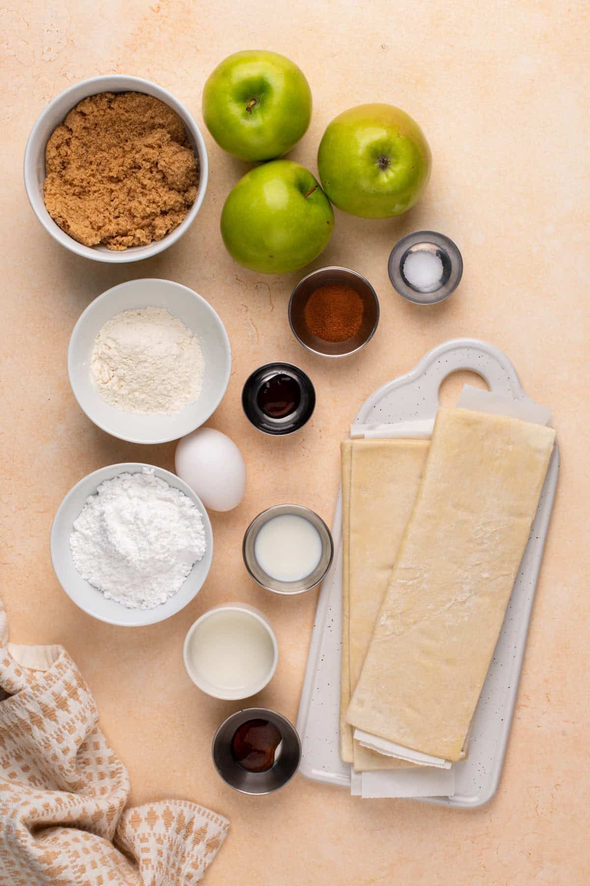 Ingredients for puff pastry apple strudel arranged on a countertop.