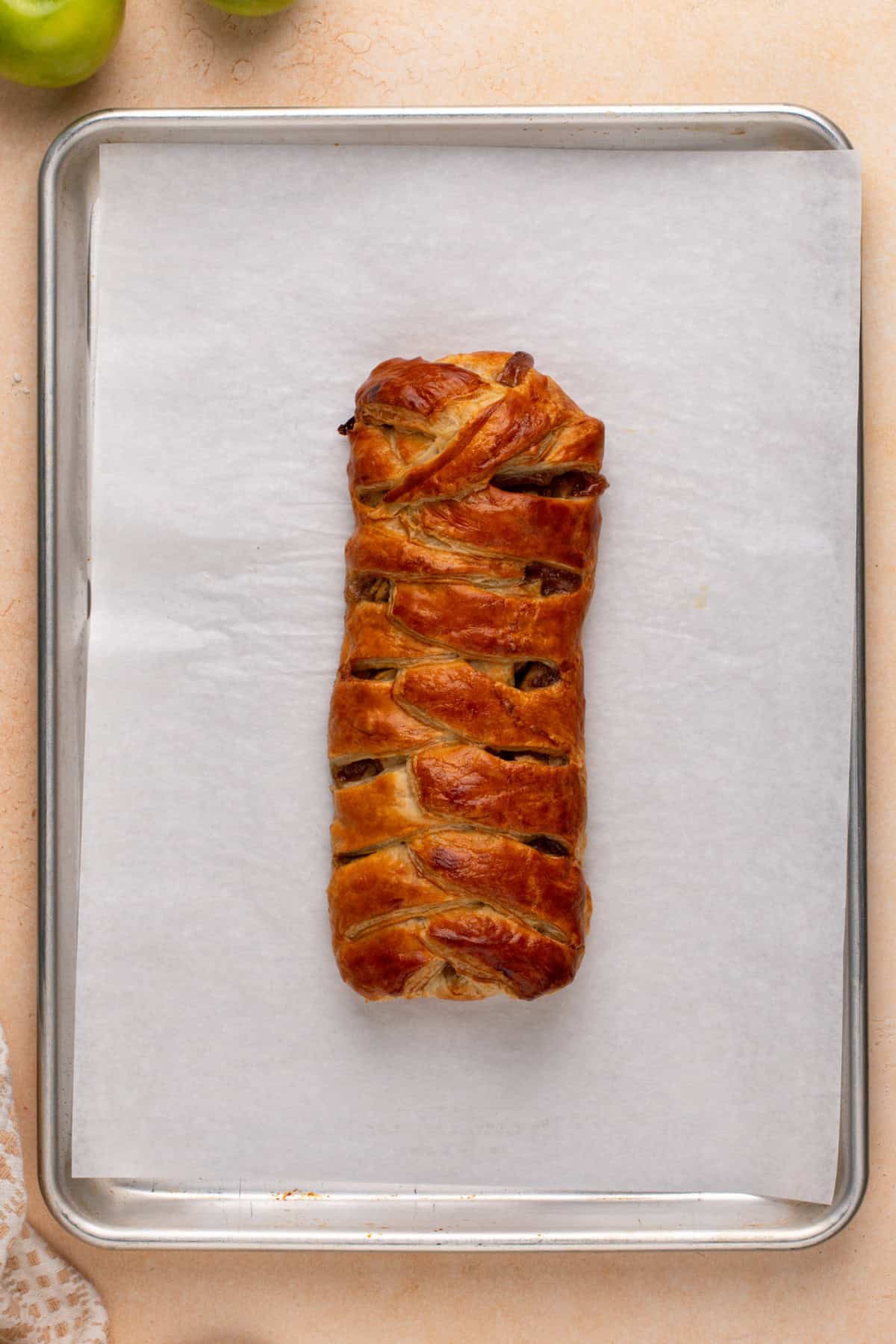 Baked apple strudel cooling on a baking sheet.
