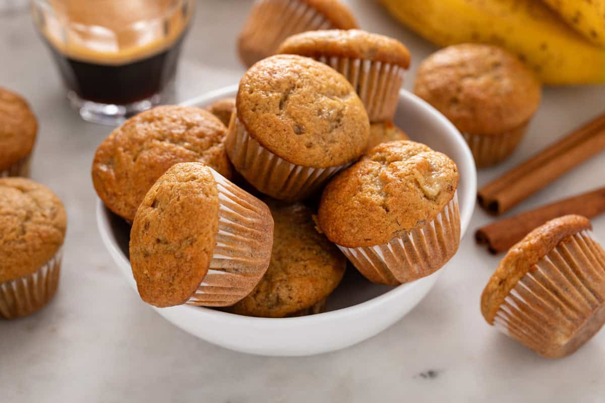 Mini banana muffins arranged in a white bowl.