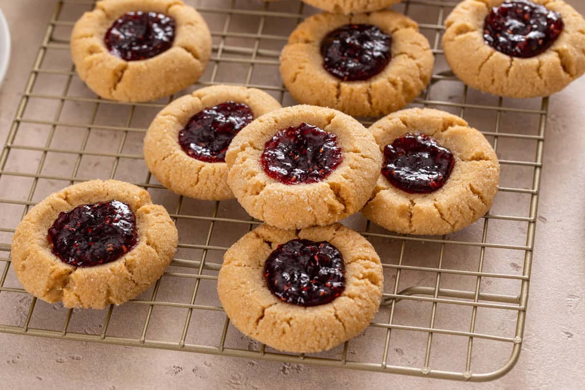 Peanut butter and jelly cookies arranged on a cooling rack.