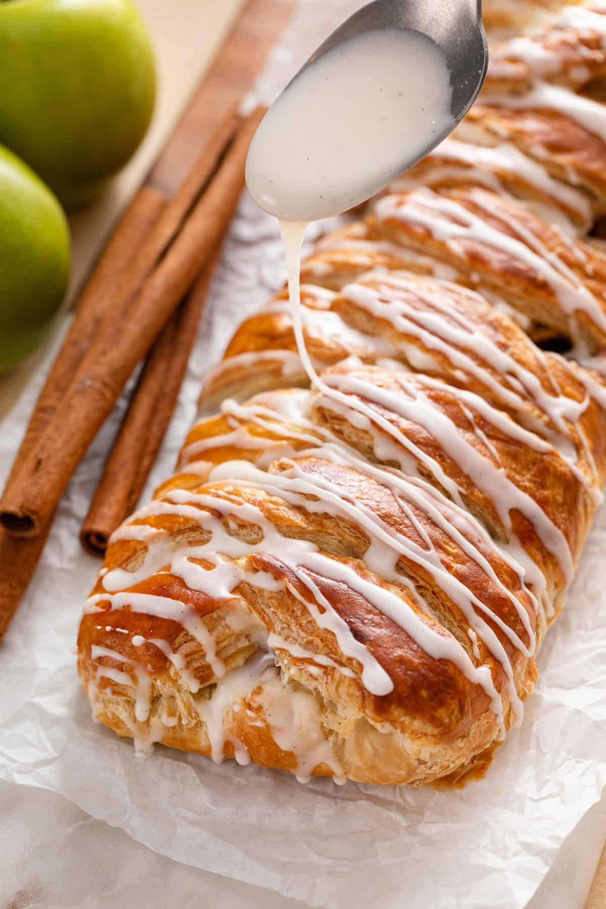 Vanilla glaze being drizzled over apple strudel.