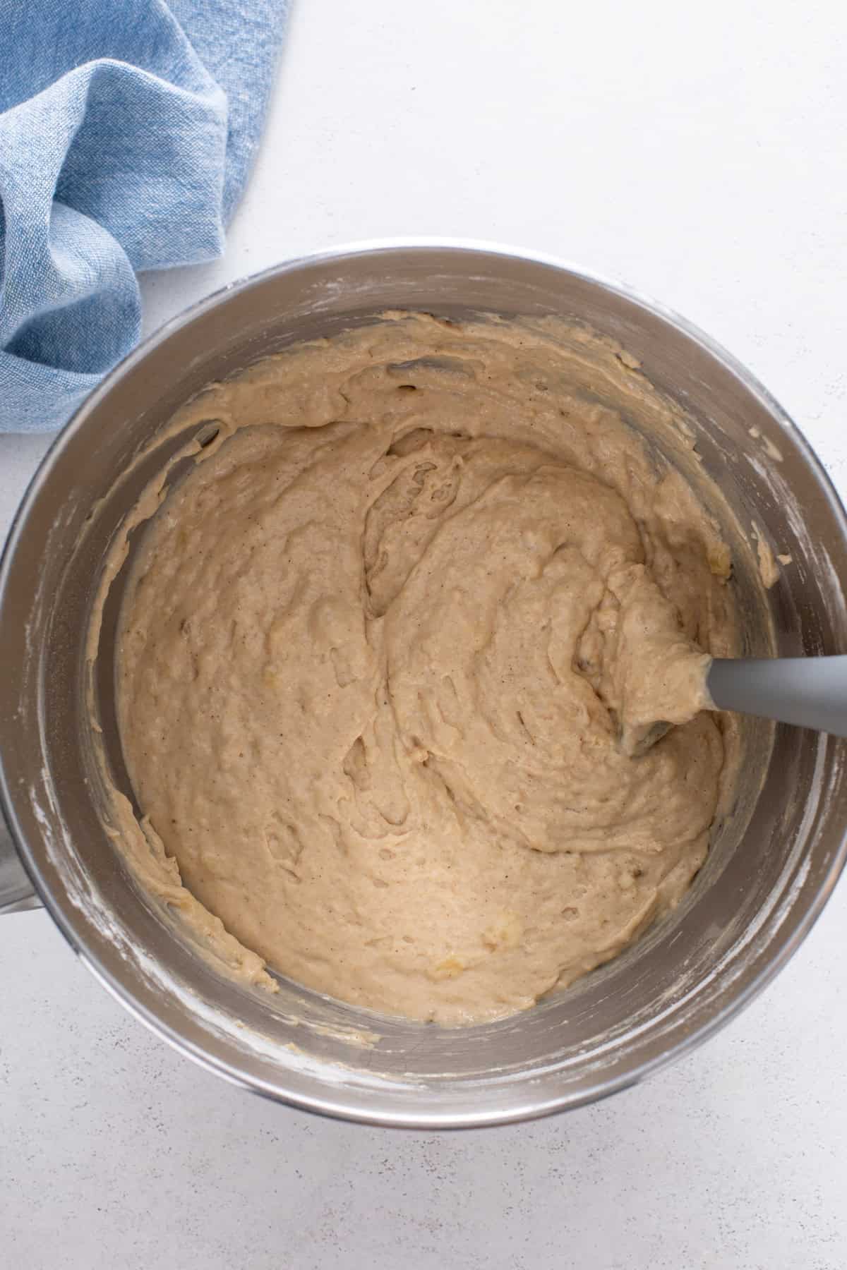 Mini banana muffin batter mixed in a metal bowl.