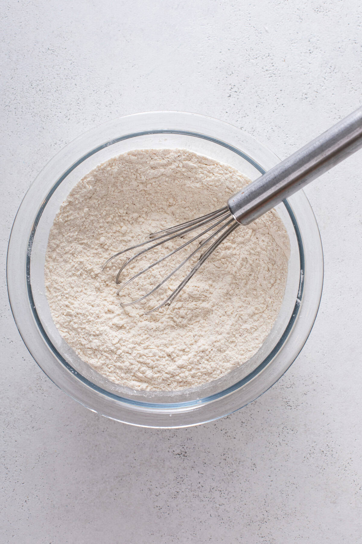 Dry ingredients for mini banana muffins whisked in a glass bowl.