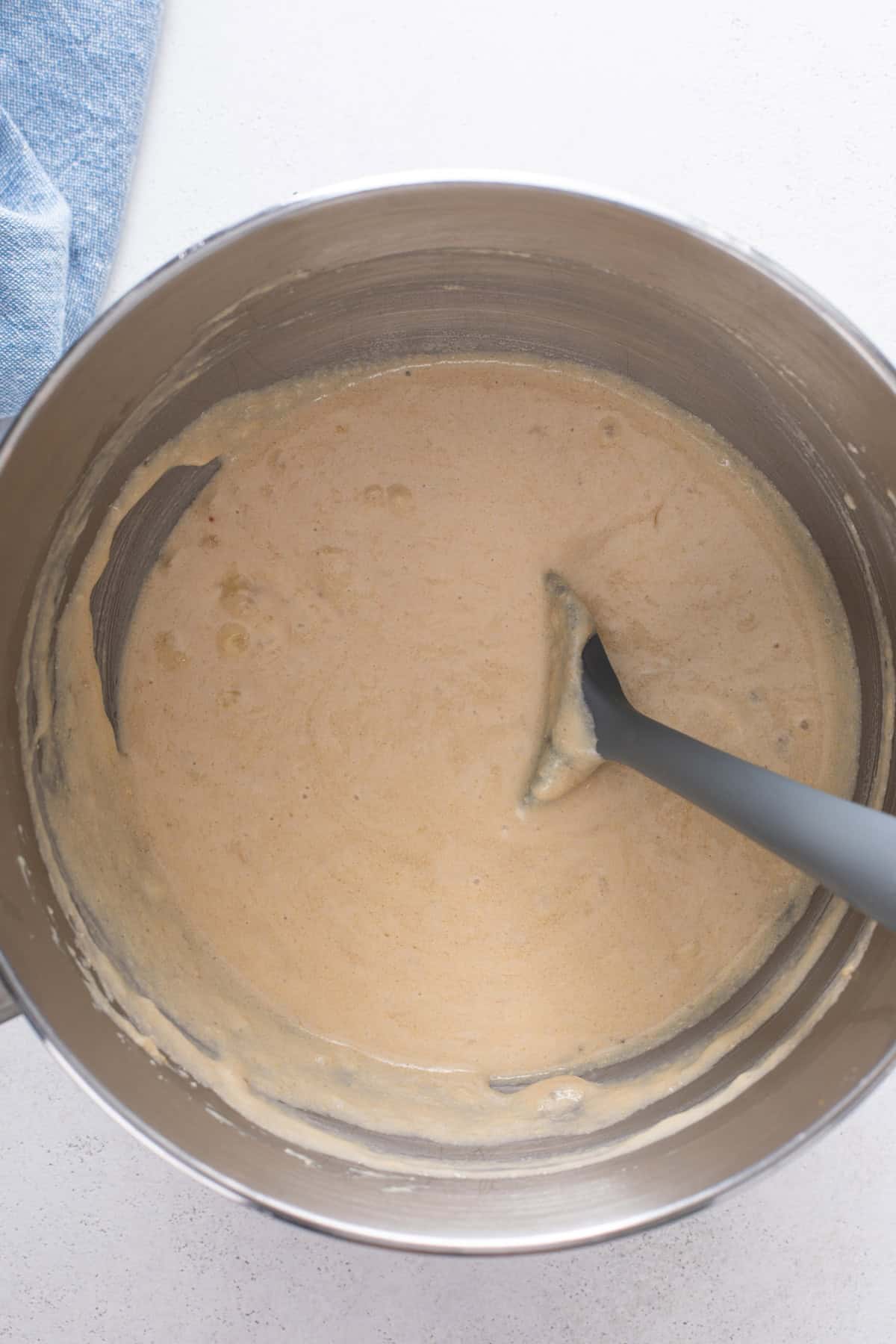 Wet ingredients for mini banana muffins stirred together in a metal bowl.