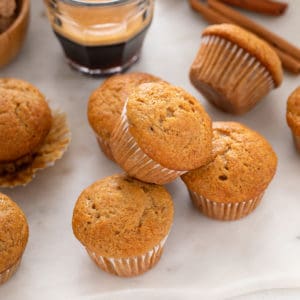Several mini banana muffins arranged on a countertop.