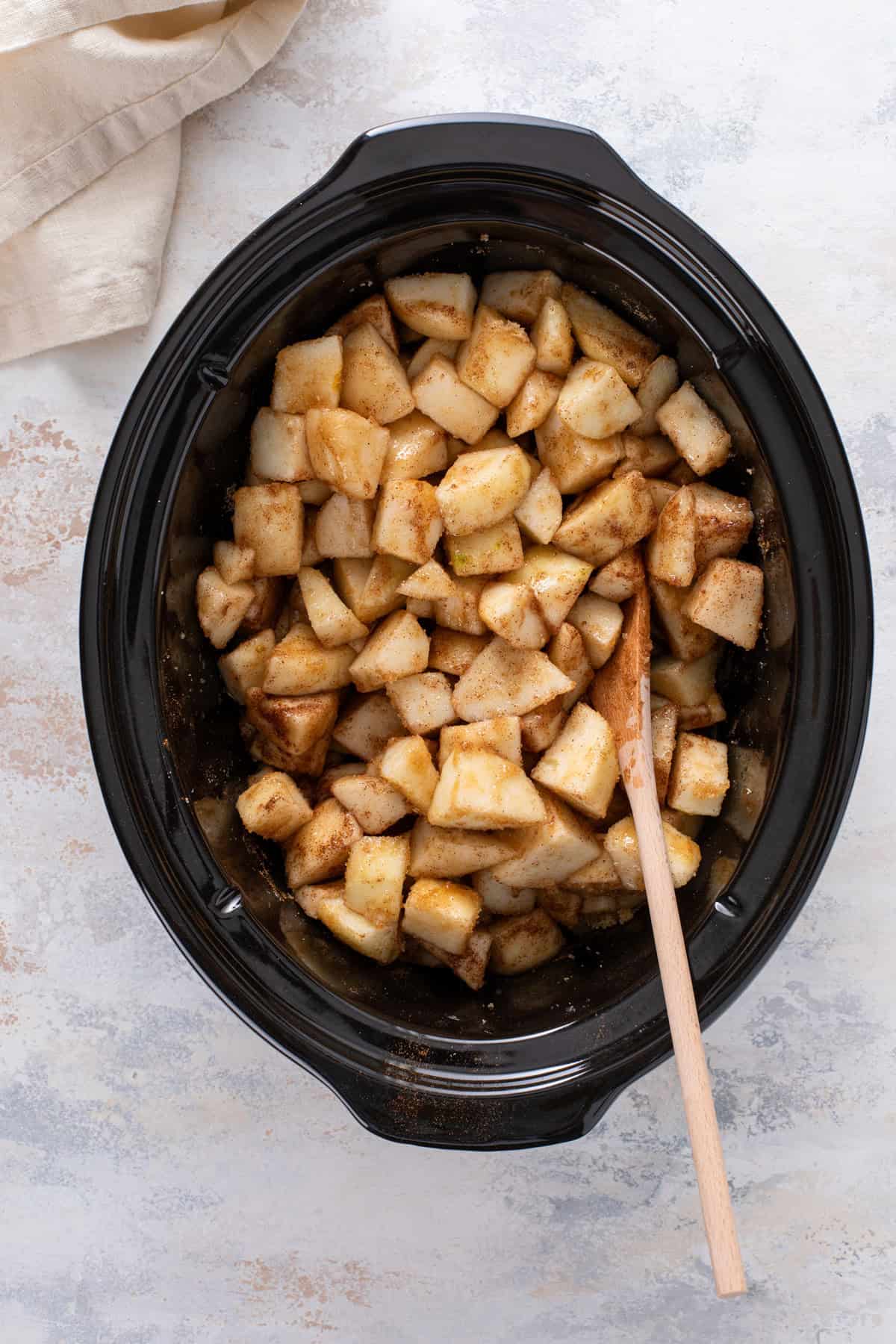 Ingredients for pear butter mixed in the crock of a slow cooker.