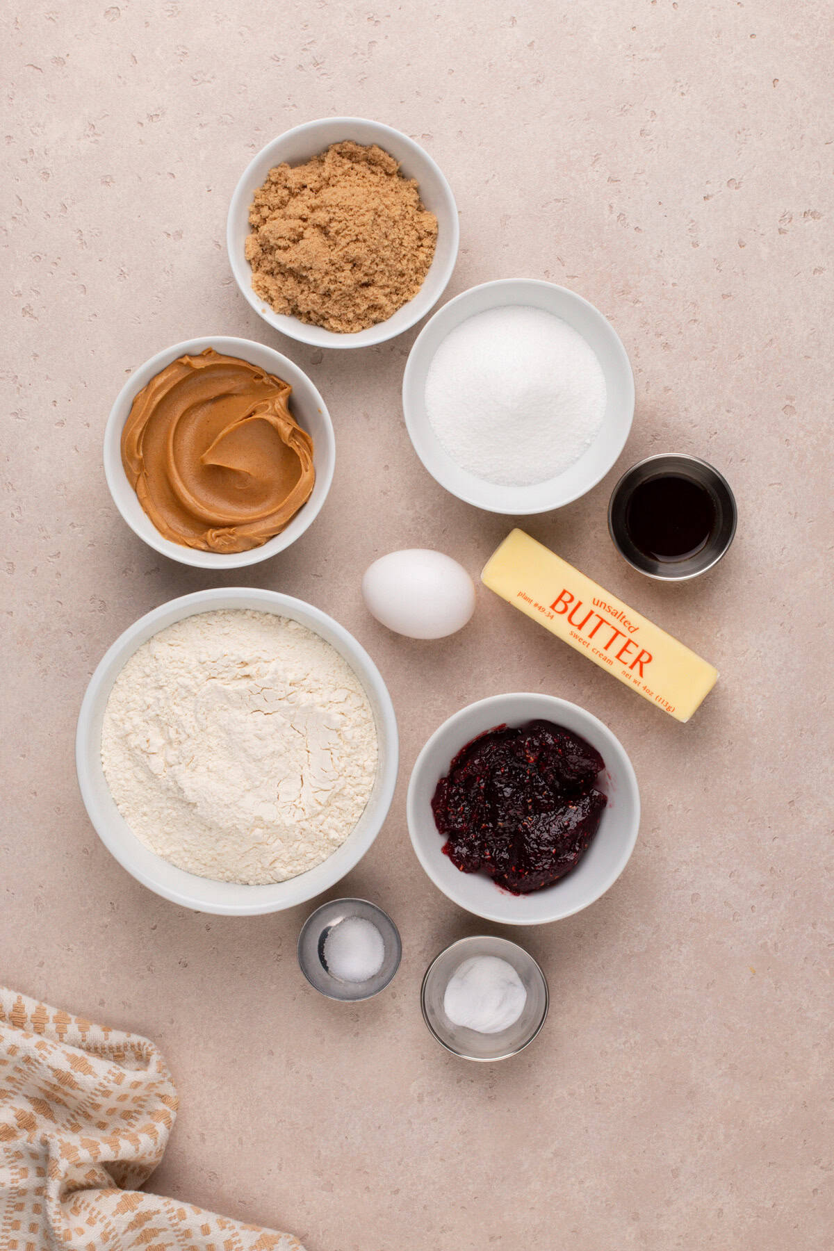 Ingredients for peanut butter and jelly cookies arranged on a countertop.