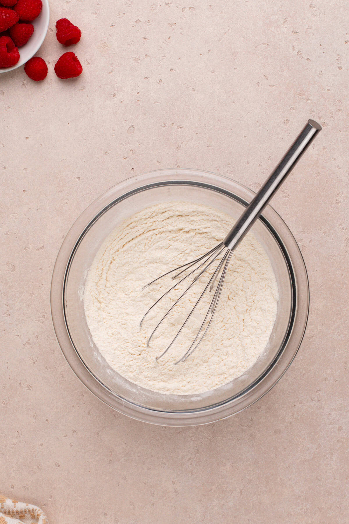 Dry ingredients for peanut butter and jelly cookies whisked in a glass bowl.