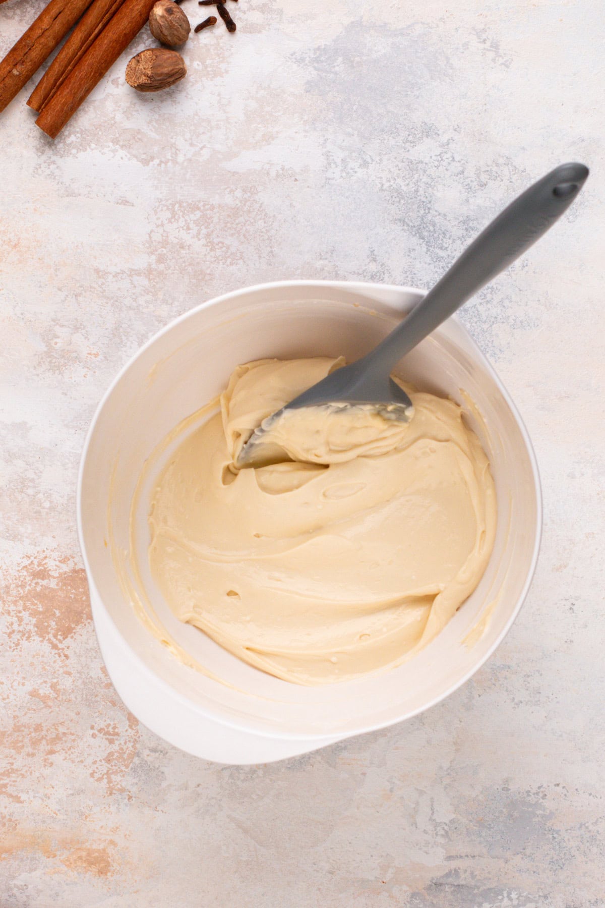 Cream cheese filling for pumpkin bread mixed in a white bowl.