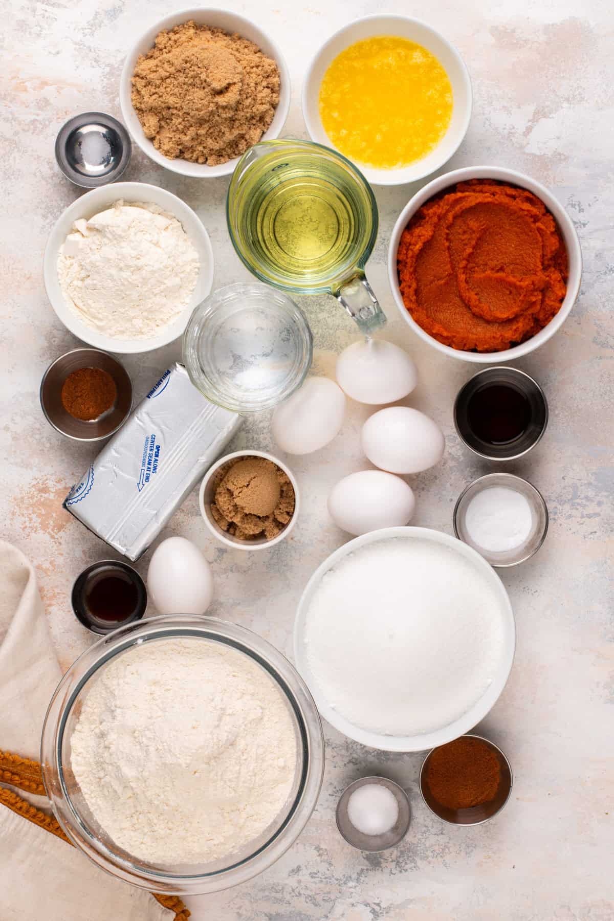 Ingredients for pumpkin cream cheese bread arranged on a countertop.
