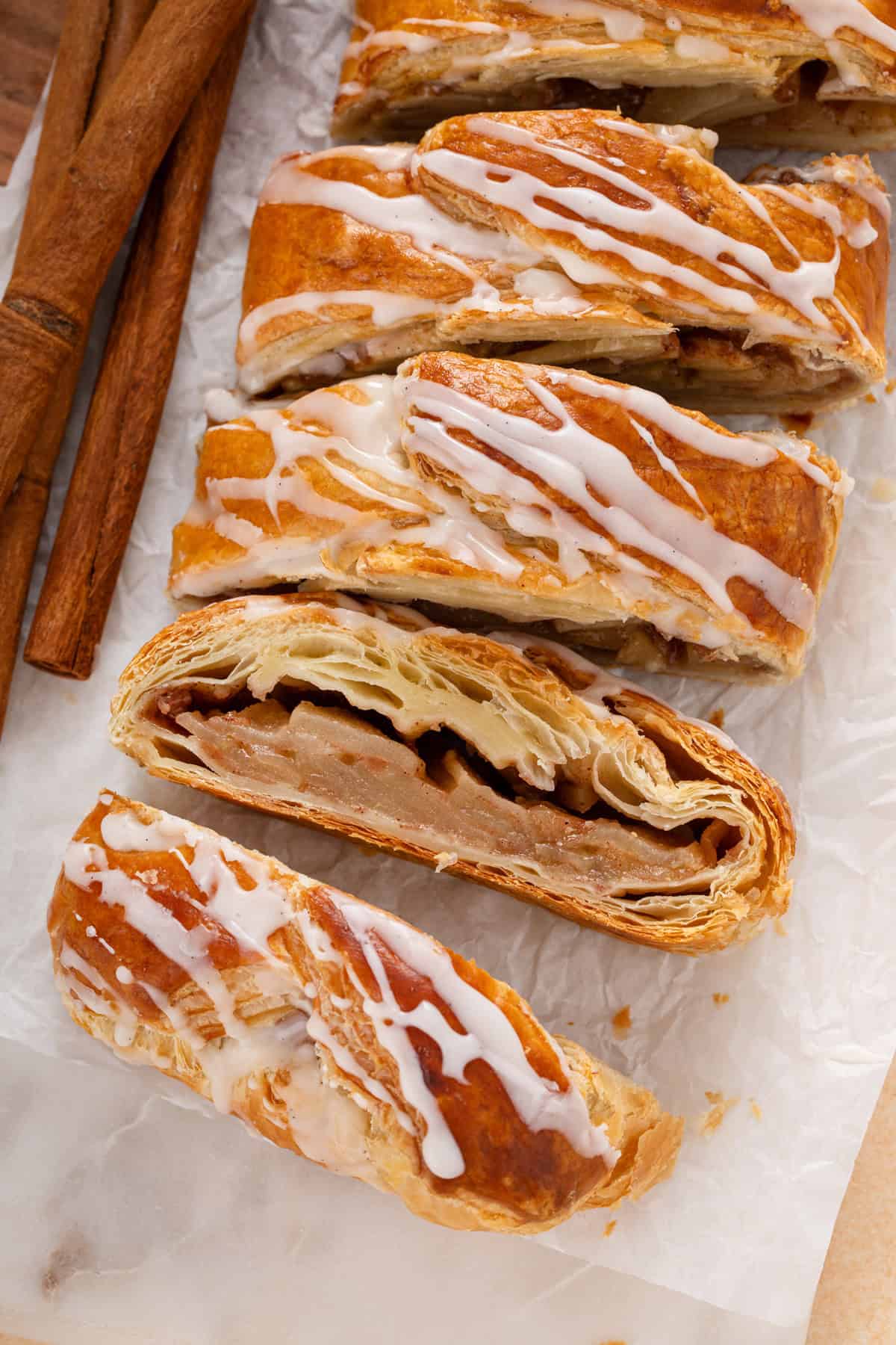 Slices of puff pastry apple strudel on a piece of parchment paper.