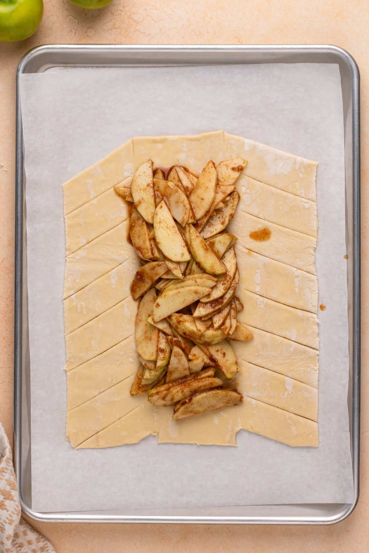 Strips cut into puff pastry on the either side of strudel filling.