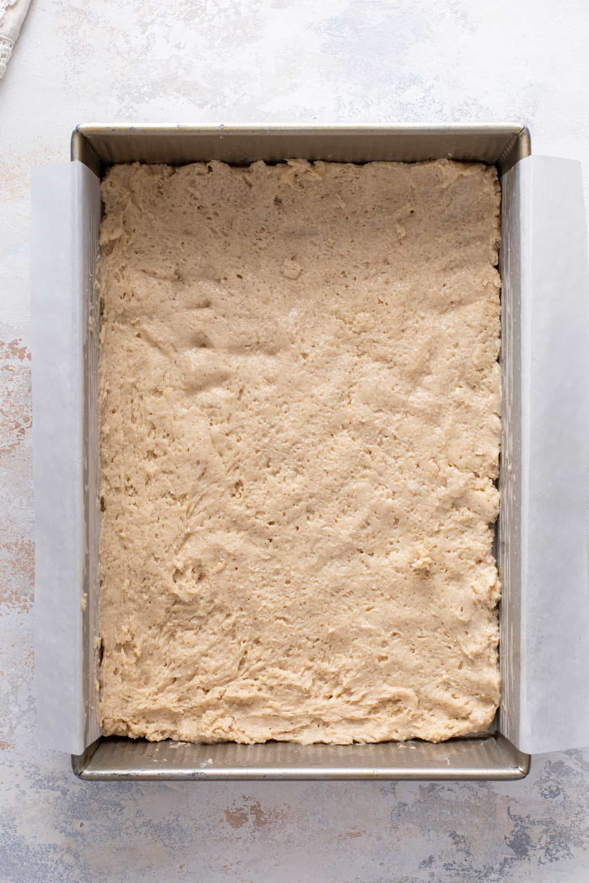 Bottom layer of batter spread into a pan for cream cheese coffee cake.