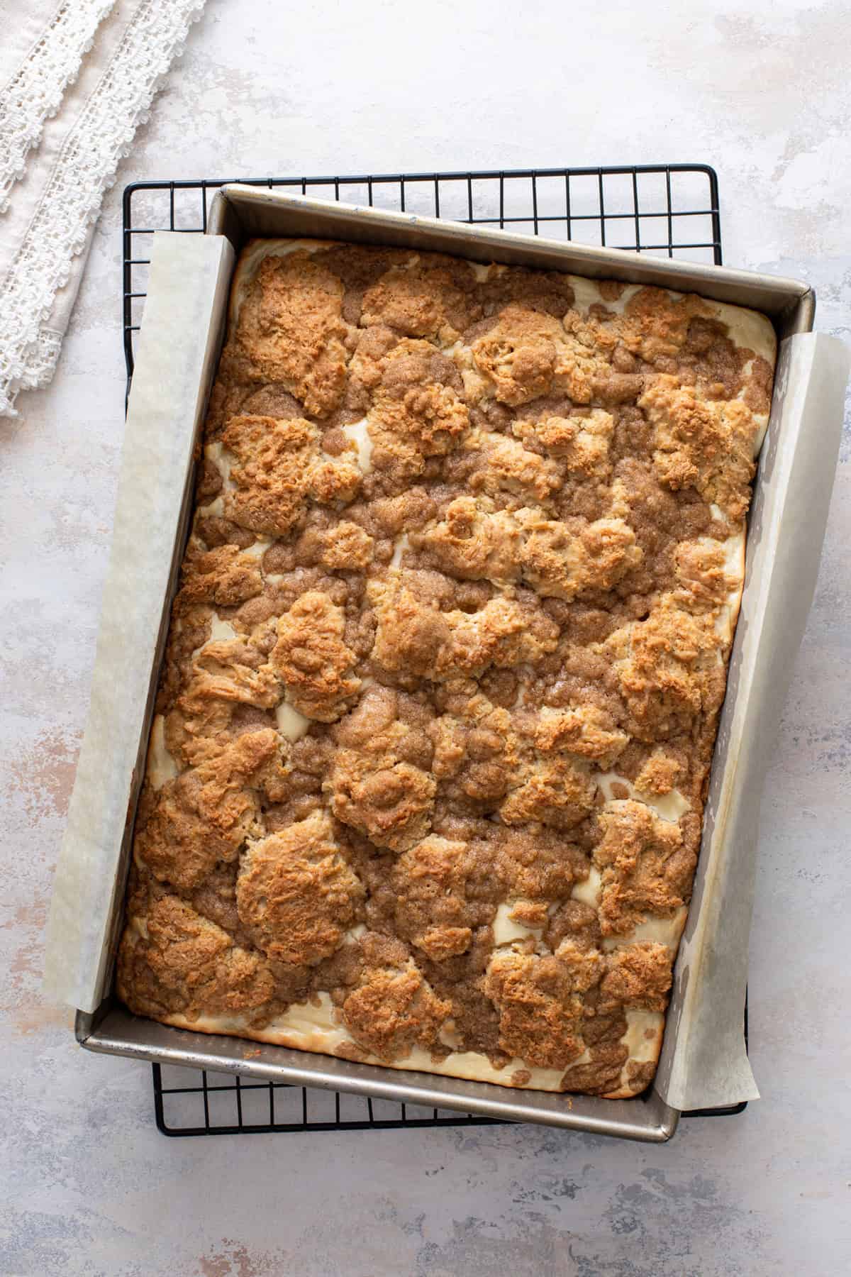 Baked cream cheese coffee cake cooling in the pan on a wire rack.
