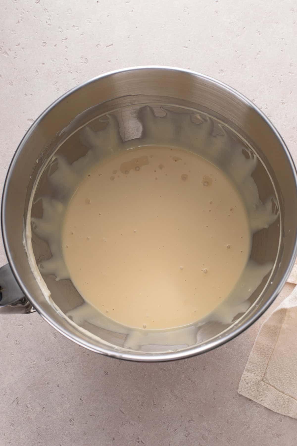 Base for cheesecake pie filling mixed in a metal bowl.