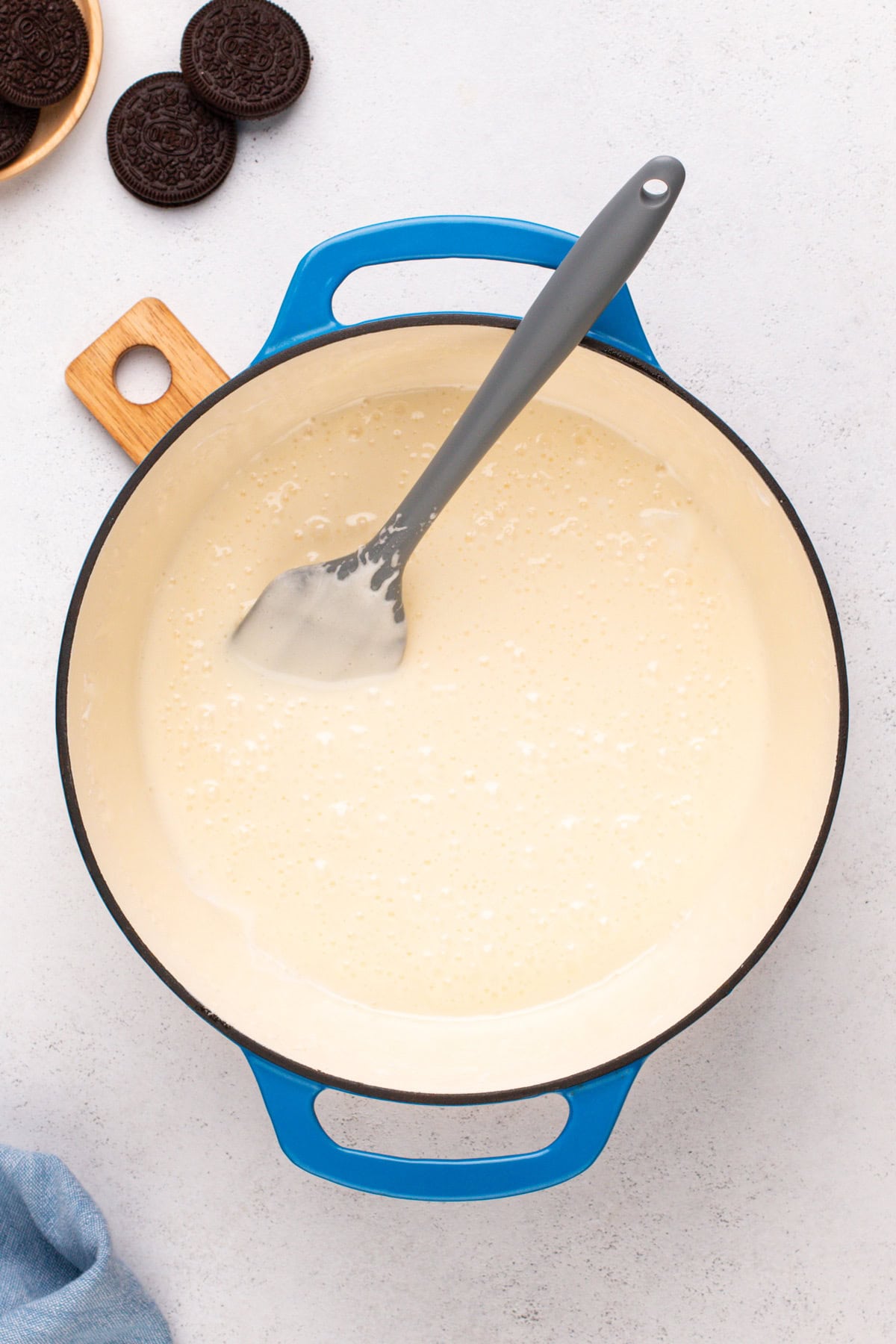 Melted marshmallow mixture for rice krispie treats in a blue dutch oven.