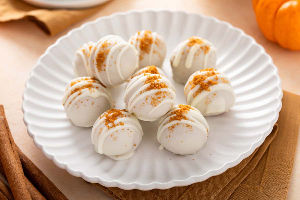 Several pumpkin cheesecake balls arranged on a white plate.