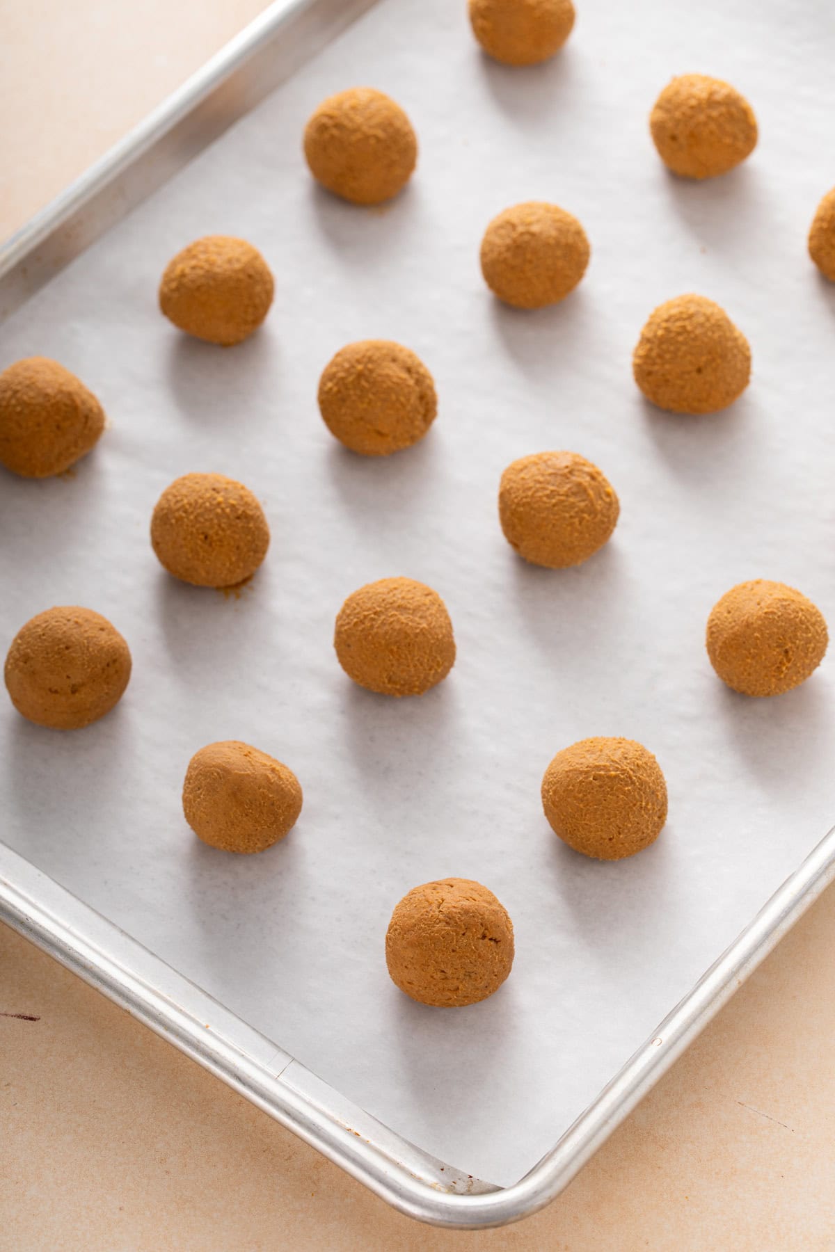 Portioned and shaped balls of filling for pumpkin cheesecake balls.