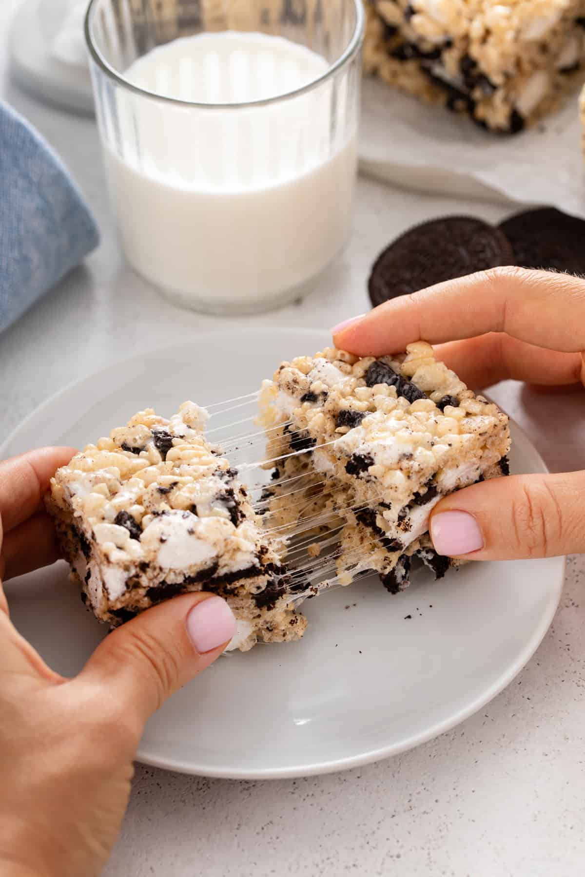 Person pulling apart an oreo rice krispie treat to show the gooey texture.