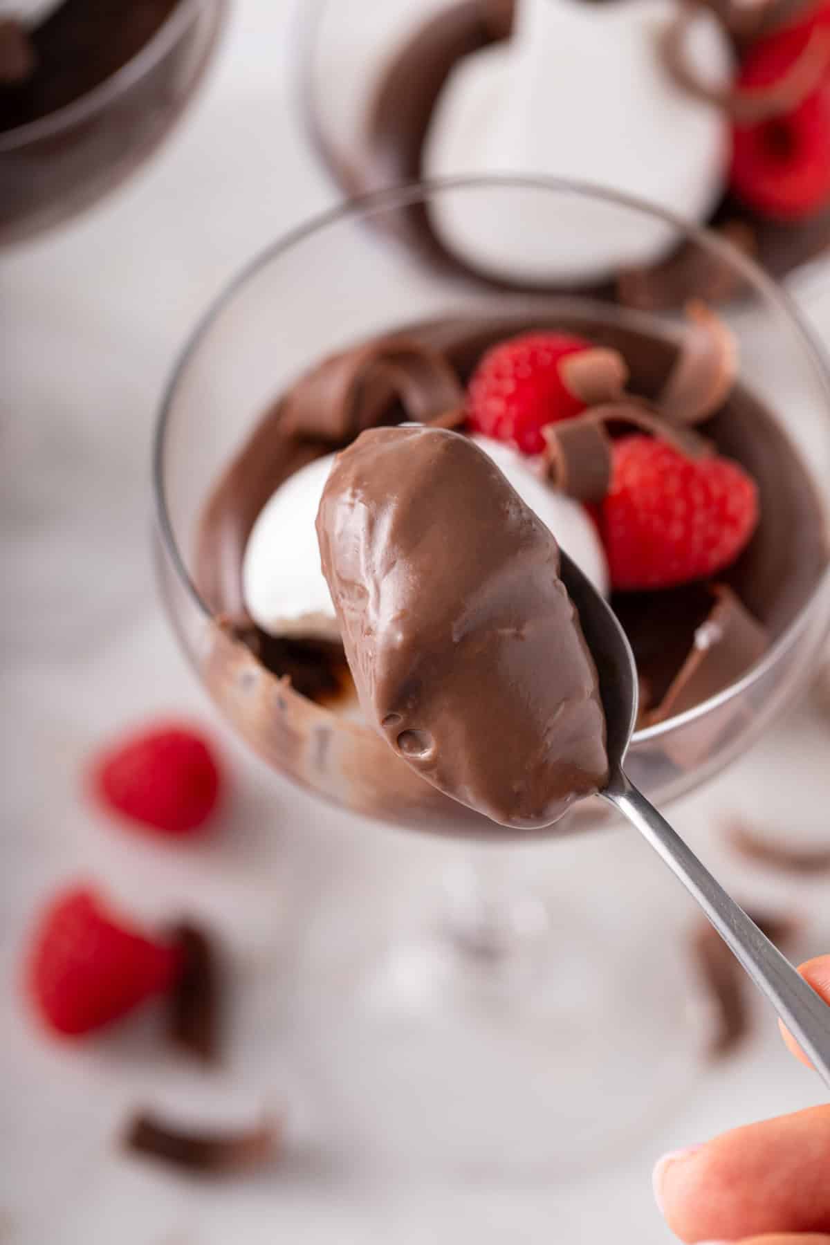 Spoon holding up a bite of homemade chocolate pudding.