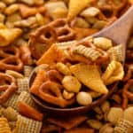 Wooden spoon holding a serving of ranch chex mix.