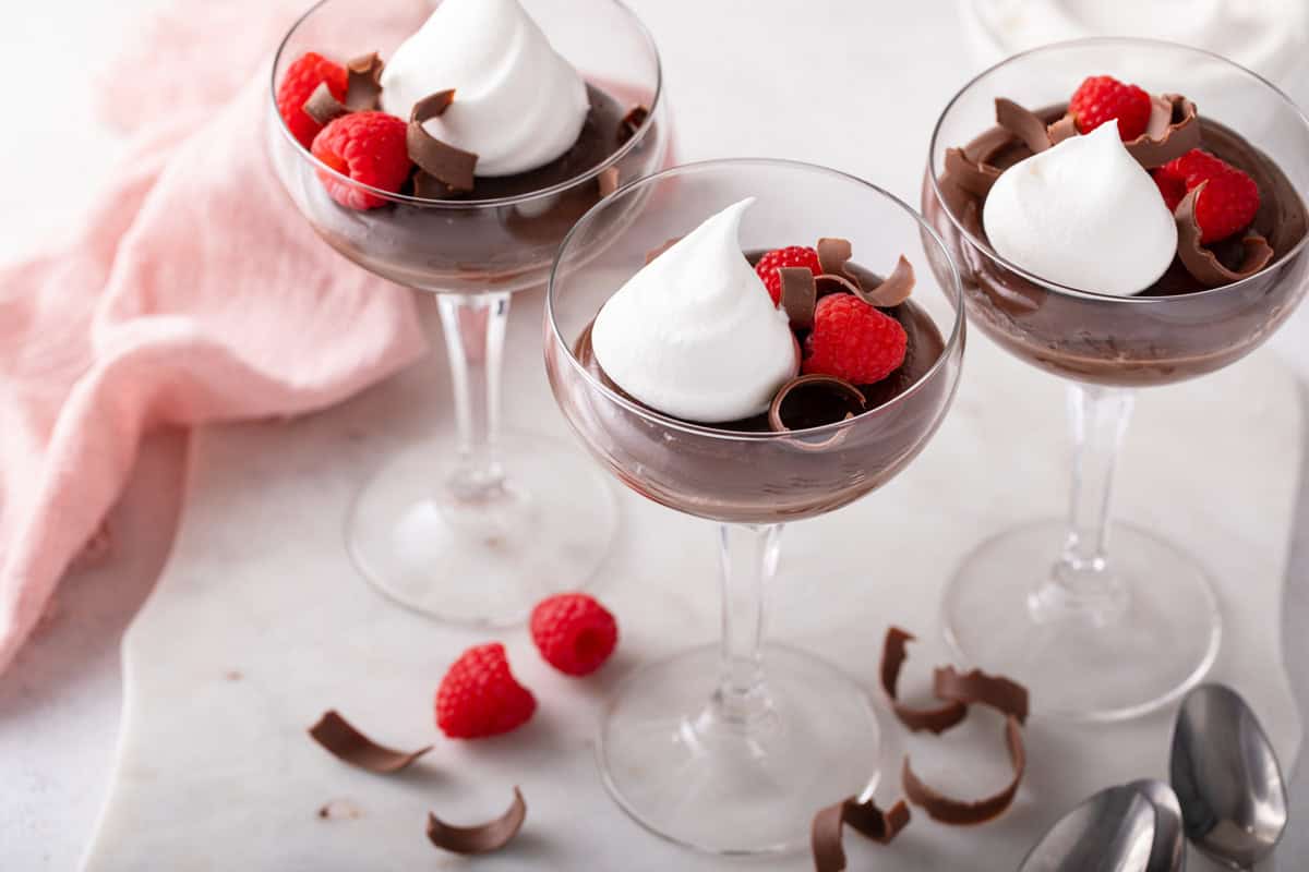 Three coupe glasses filled with homemade chocolate pudding.