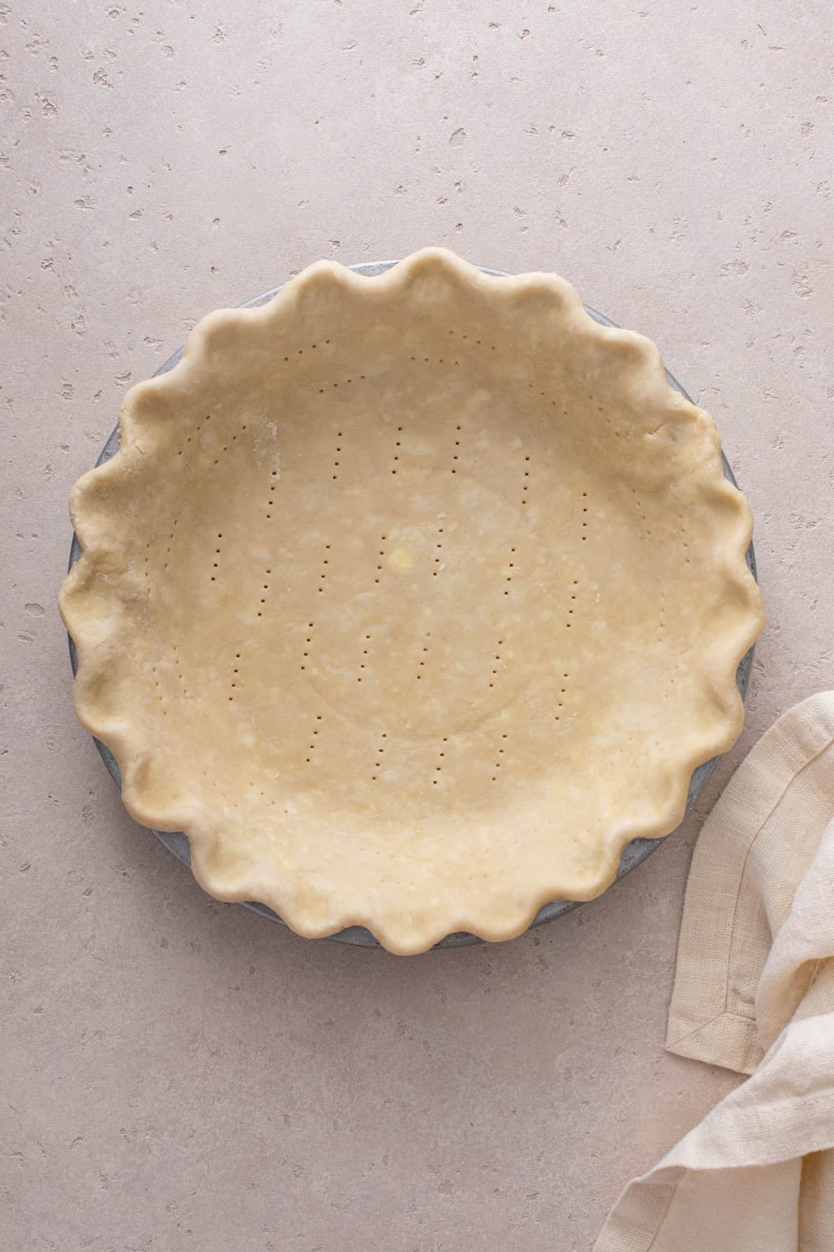 Unbaked pie shell, docked and ready to be blind baked.