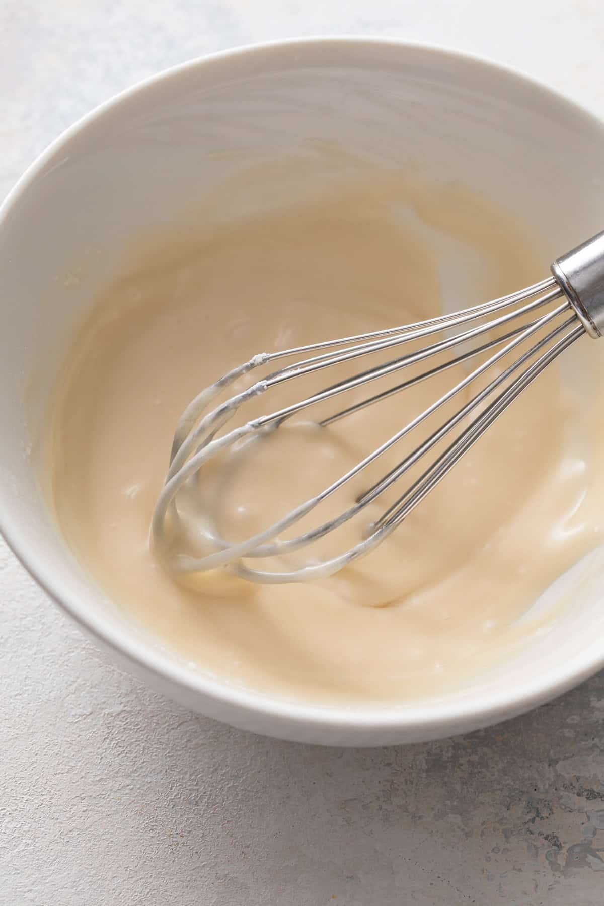 Vanilla glaze being whisked in a bowl.