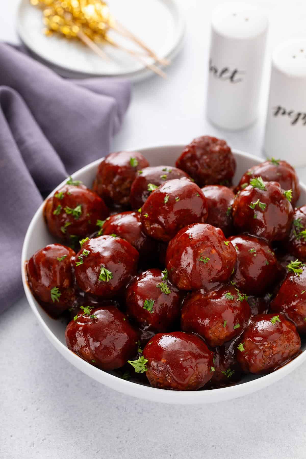 White serving bowl filled with cranberry meatballs.