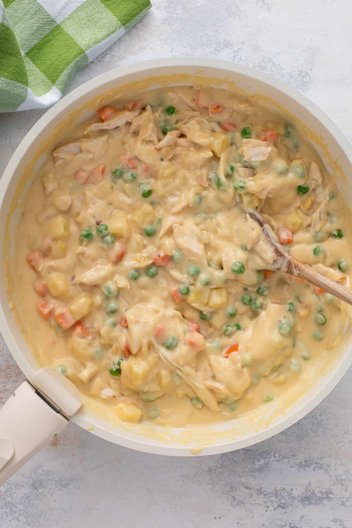 Chicken pot pie filling in a skillet.