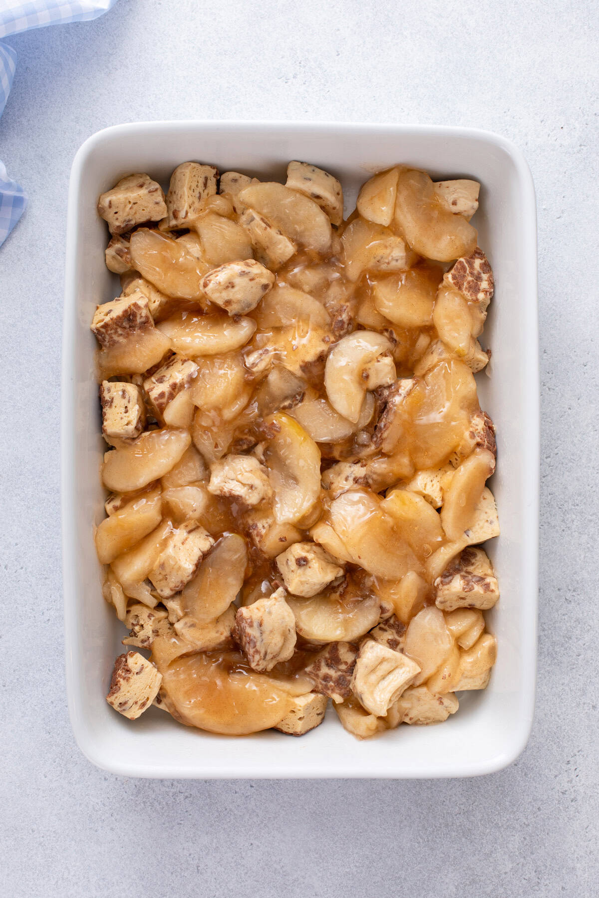 Cinnamon roll dough and pie filling mixed in a baking dish.