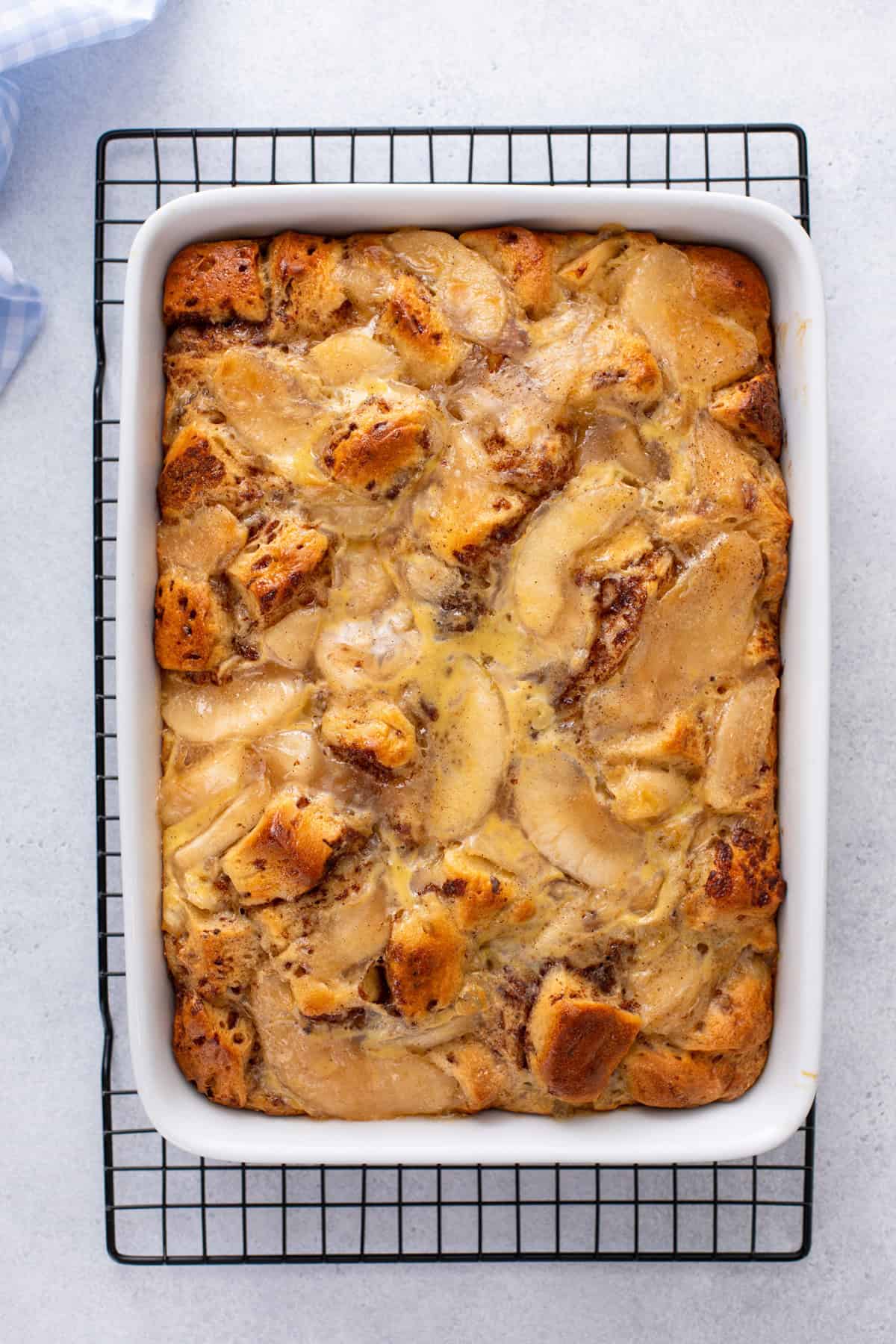 Baked cinnamon roll casserole cooling on a wire rack.