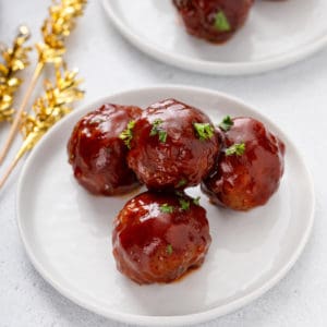 Appetizer plate holding several cranberry meatballs.