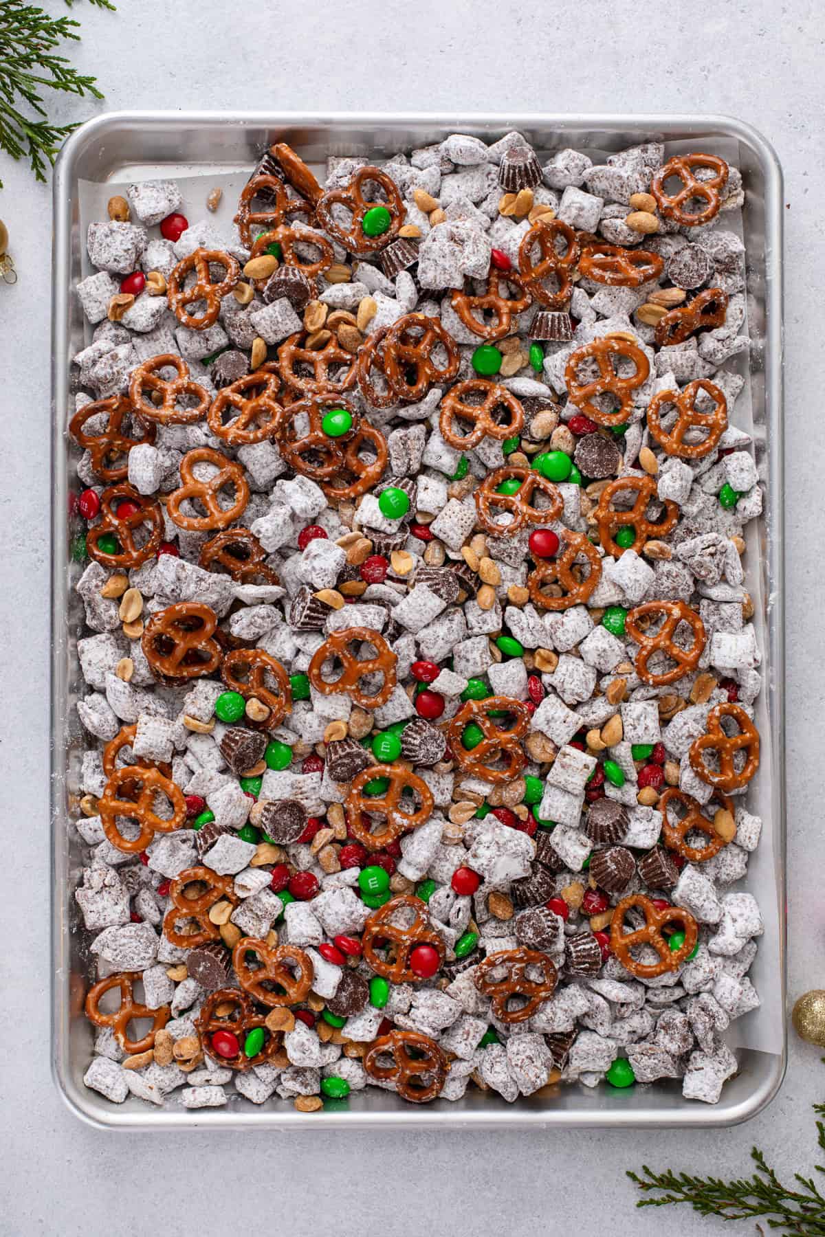 Mixed reindeer chow spread out onto a baking sheet.