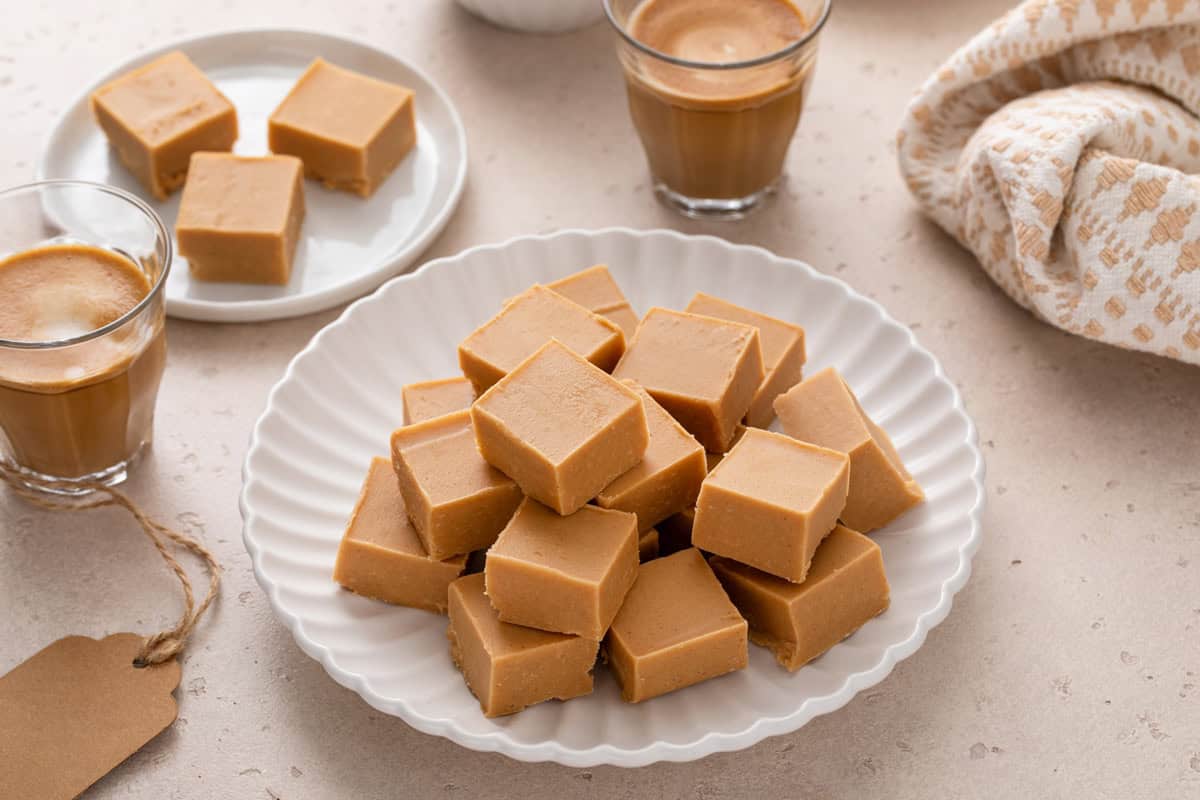Squares of peanut butter fudge arranged on a white plate.