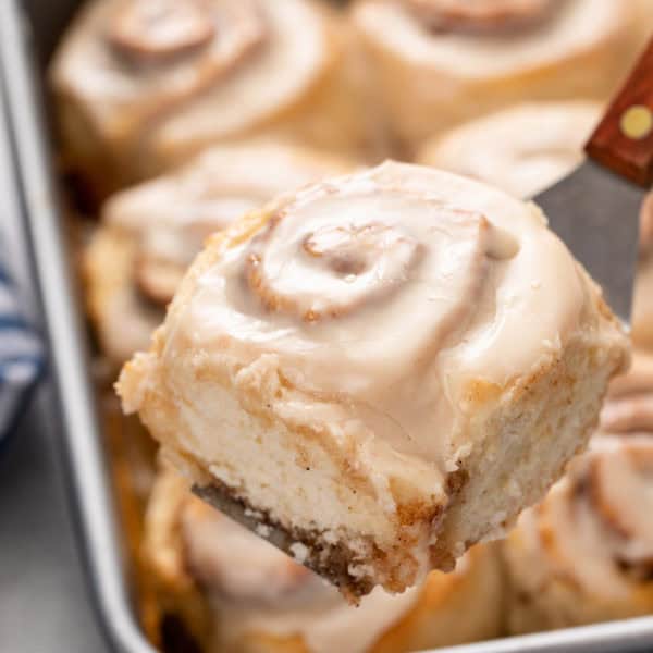 Spatula lifting up a biscuit cinnamon roll.