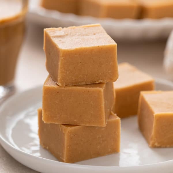 Easy peanut butter fudge stacked on a white plate.