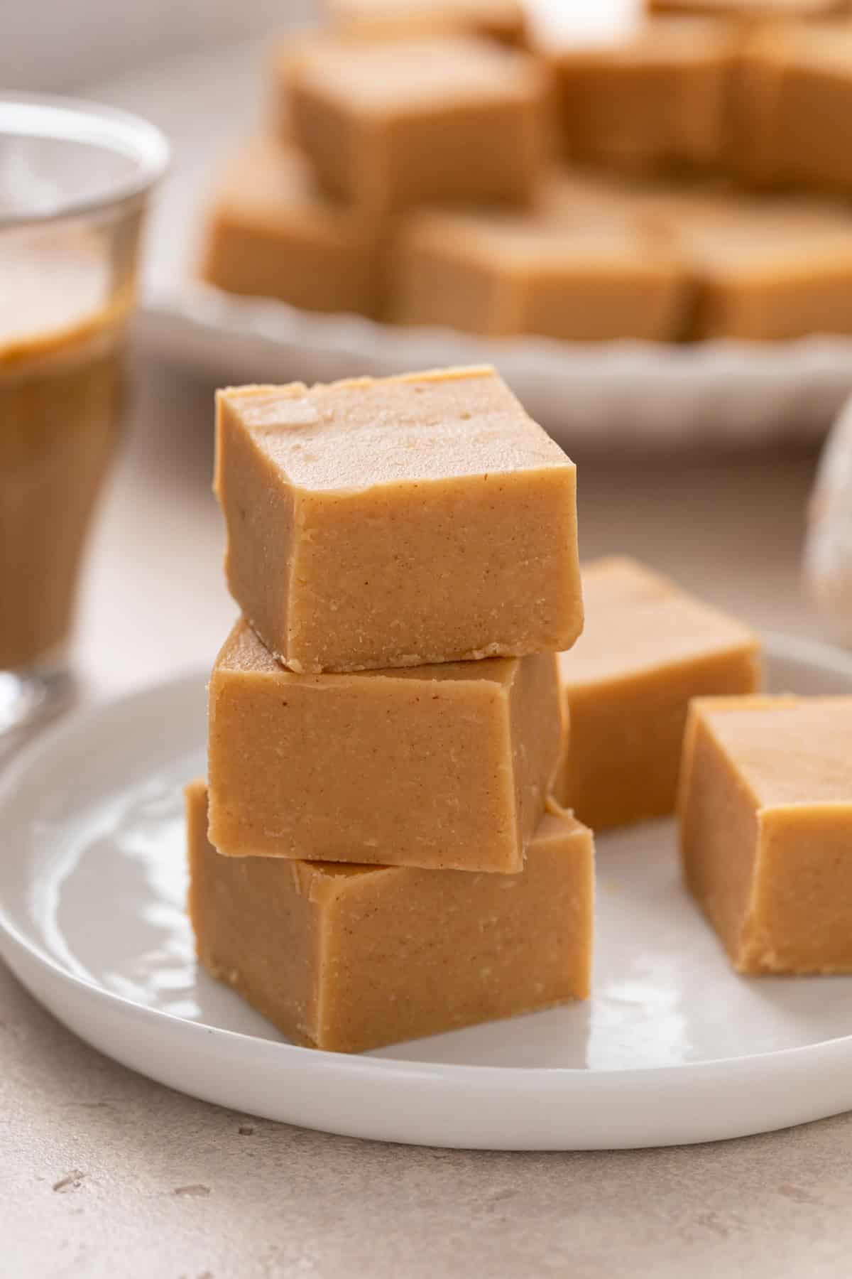 Three pieces of peanut butter fudge stacked on a white plate.