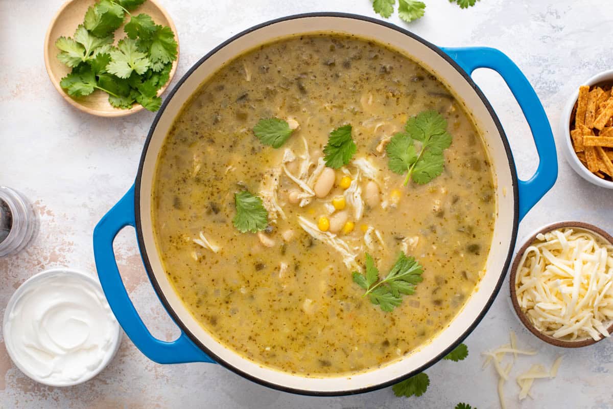 White chicken chili in a blue dutch oven on a countertop.