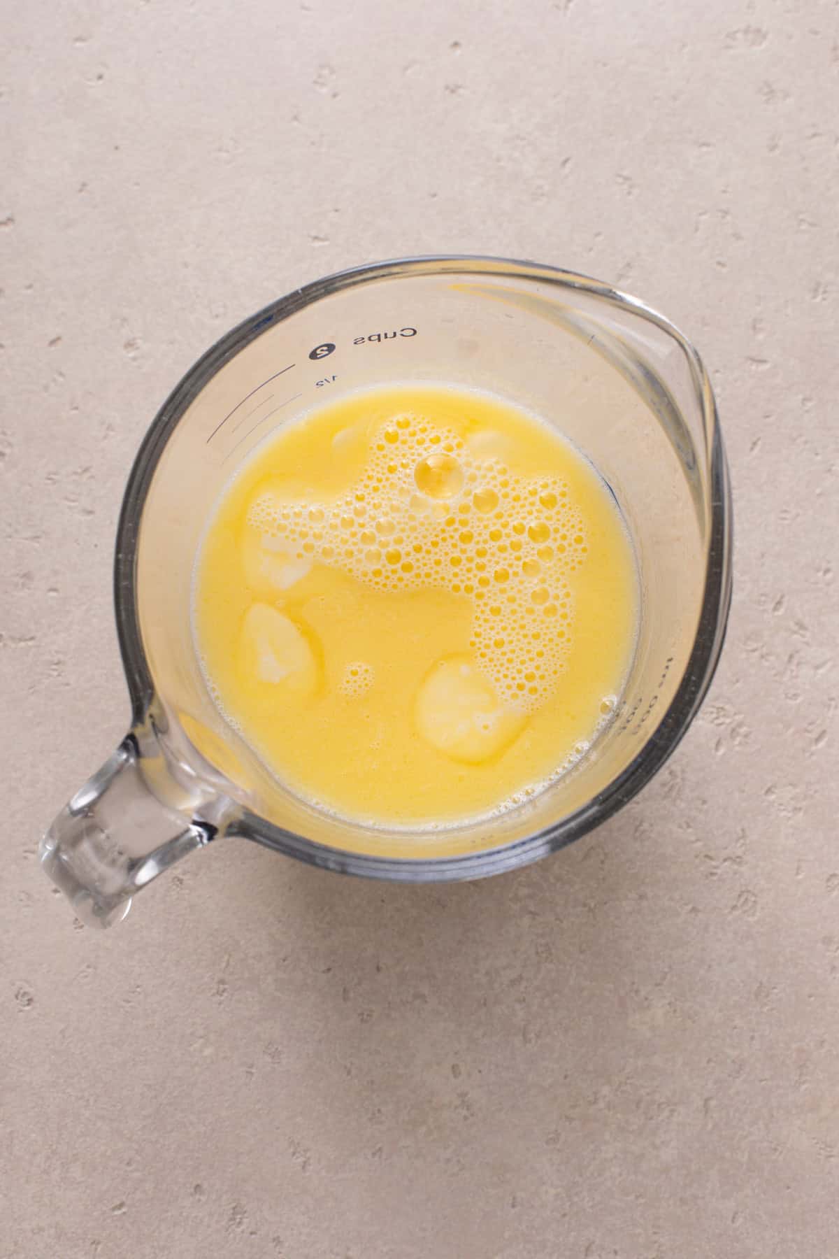 Wet ingredients for potato bread mixed in a measuring cup.