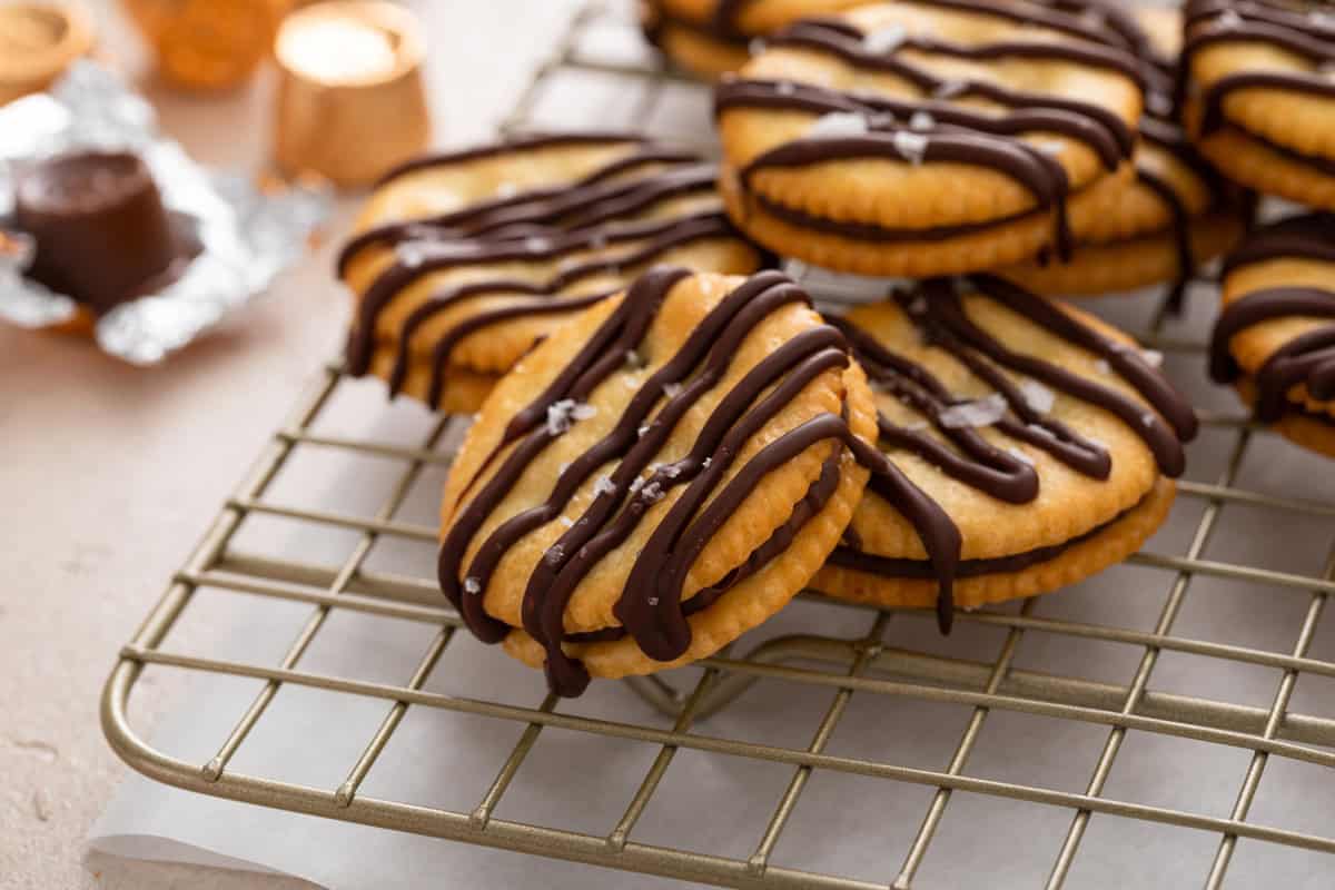 Rolo ritz cracker cookies piled on a wire rack.