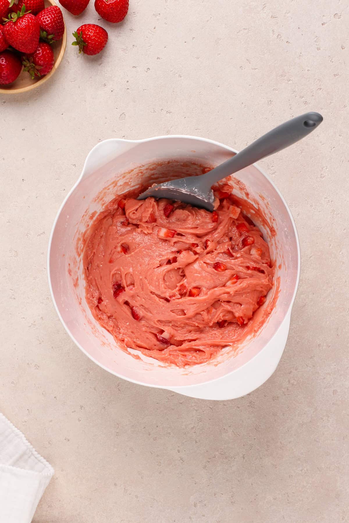 Strawberry brownie batter mixed in a white bowl.