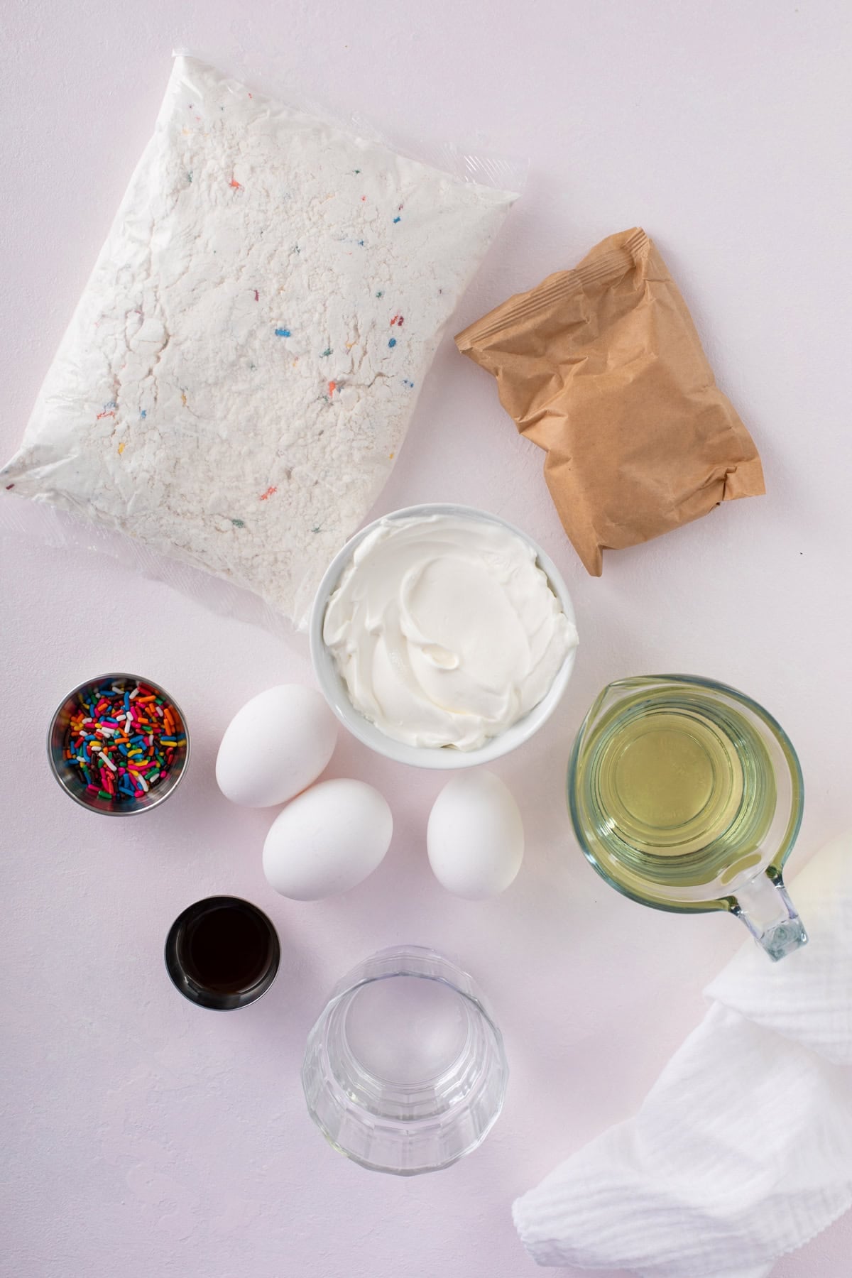 Ingredients for easy funfetti cake arranged on a countertop.