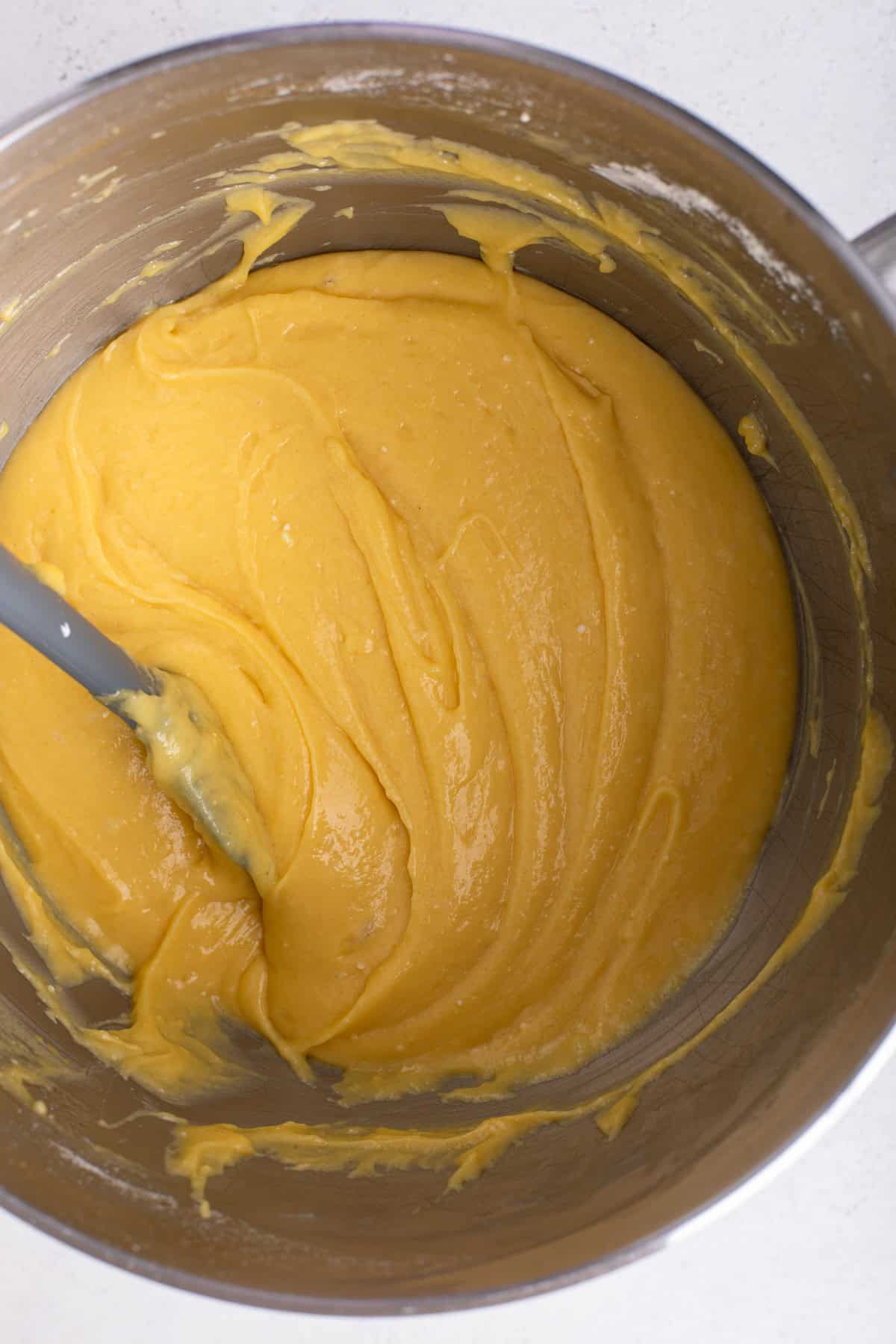 Batter for easy yellow cake mixed in a stainless steel bowl.
