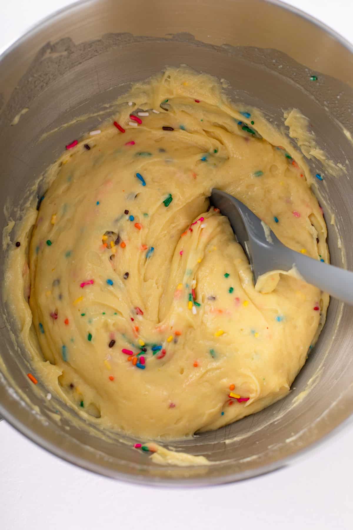 Easy funfetti cake batter mixed in the bowl of a stand mixer.