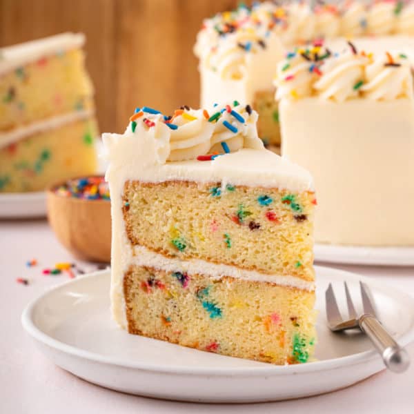 Slice of easy funfetti layer cake on a white plate.